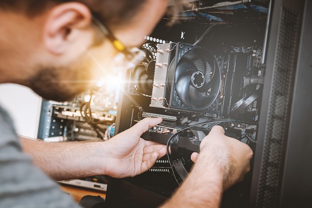 Image of person installing computer hardware into computer case.