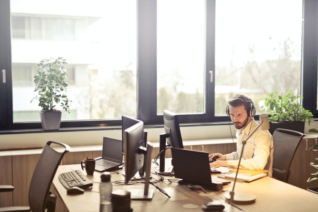 Image of a person sitting at a desk with headphones on.